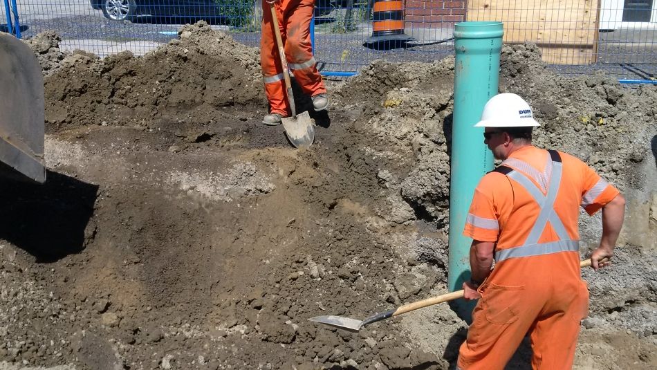Gas workers working on a gas pipe in a residential area. Gas workers working on a gas pipe in a residential area.